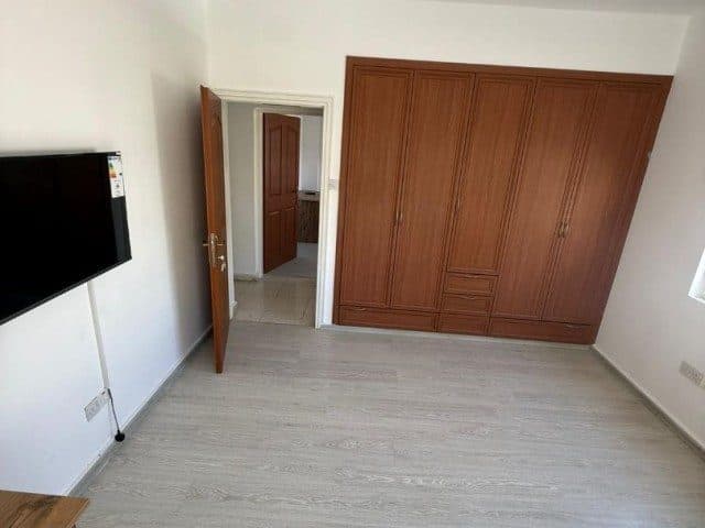 Ahşap gömme dolap ve duvara monte televizyon bulunan oda