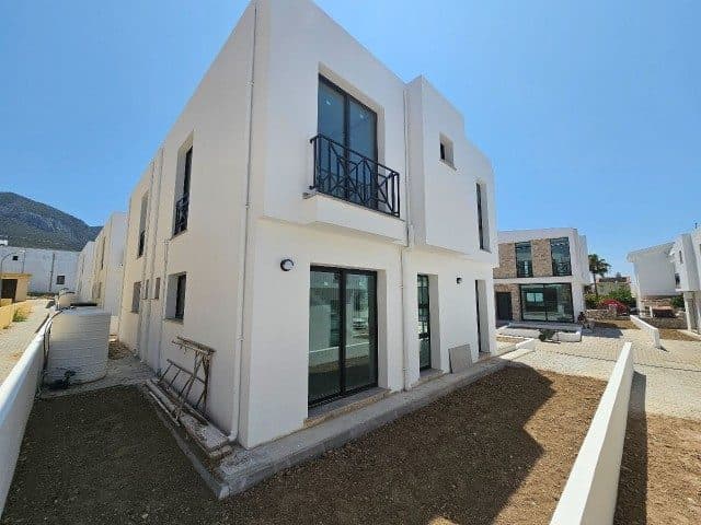 Yan cephede balkon, geniş camlar ve toprak bahçe alanı