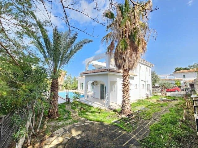 Palmiye ağaçları önünde iki katlı beyaz villa