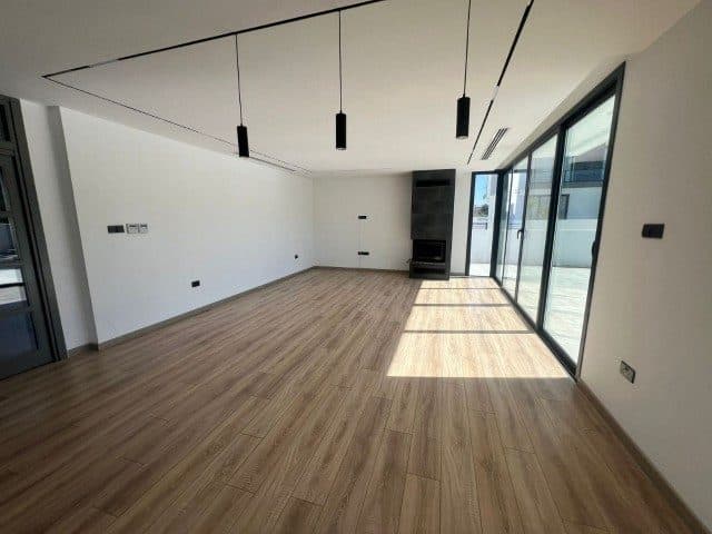 Boş salon, siyah sarkıt lambalar ve köşedeki şömine