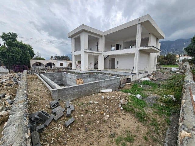 Önden görünen beton havuz ve iki katlı ev, dağların önünde