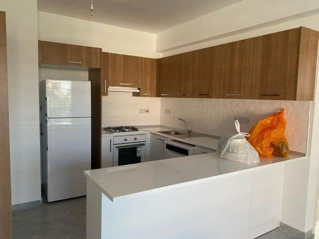 Ahşap dolaplar, beyaz tezgâh ve paslanmaz buzdolabı