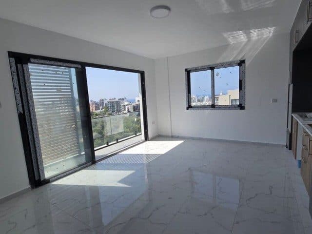 The empty living area opens through sliding glass doors onto the balcony.