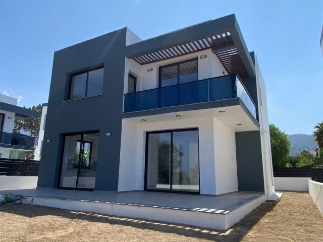 Koyu gri ve beyaz cephe, cam korkuluklu balkon ve geniş sürgülü kapılar