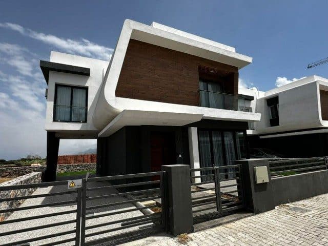 Beyaz çerçeveli cephe, ahşap görünümlü kaplama ve metal giriş kapısı