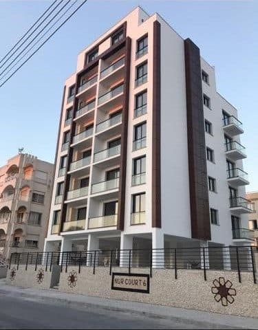 Çok katlı binanın koyu çerçeveli balkonlu ön cephesi
