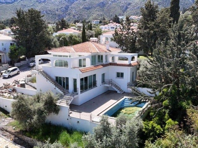 Kırmızı kiremit çatılı villa, havuz ve dağlık arka planla görünüyor