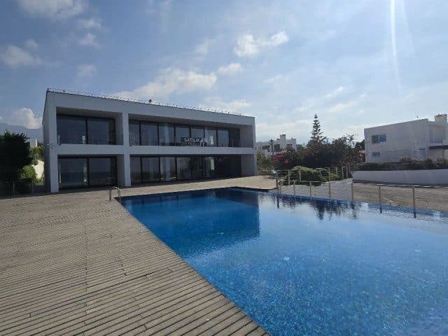 Geniş havuz, ahşap döşeme ve cam cepheli villa
