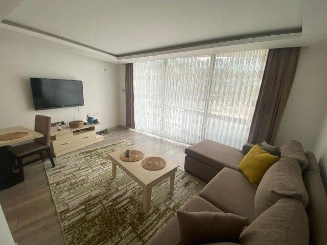 Köşe koltuk, duvara monte TV ve geniş pencereli salon