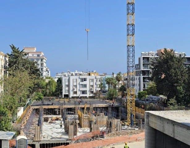 Vinç ve açık betonarme katlarla çevrili inşaat alanı