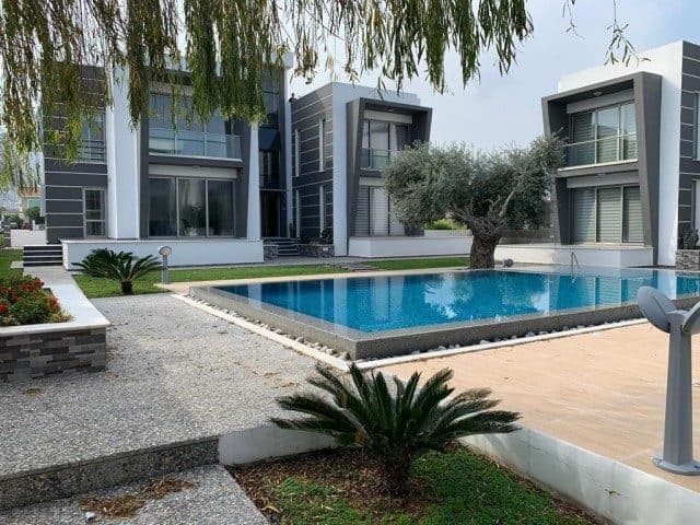 Modern cephe önünde havuz, taş yürüyüş yolu ve peyzaj