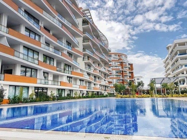 Apartman blokları ve balkonları ortak havuzun çevresinde sıralanıyor