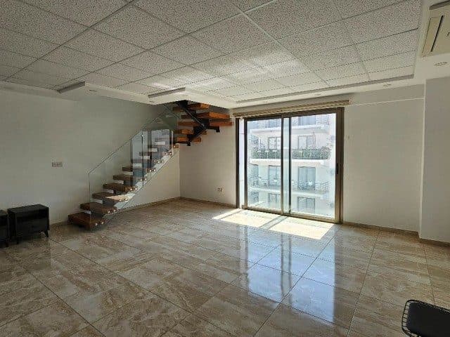 Wooden stairs and a wide sliding glass door in an empty workspace