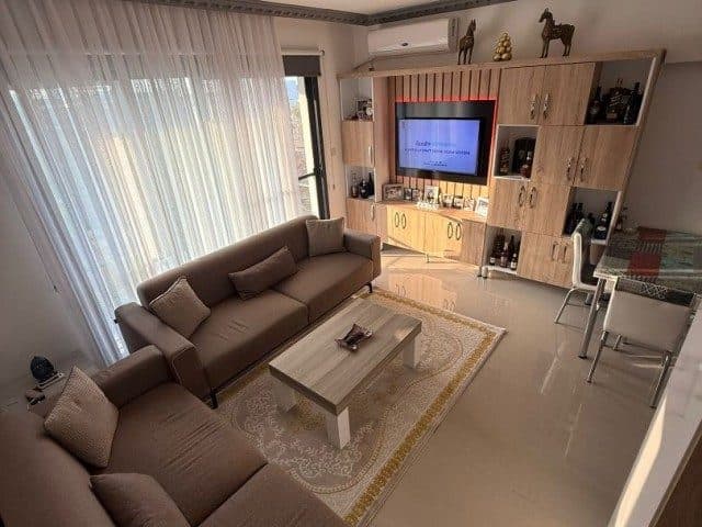 Köşe koltuk ve televizyon ünitesi yanında yemek masası