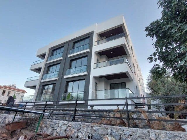 Modern cephede cam korkuluklu balkonlar ve koyu pencere çerçeveleri