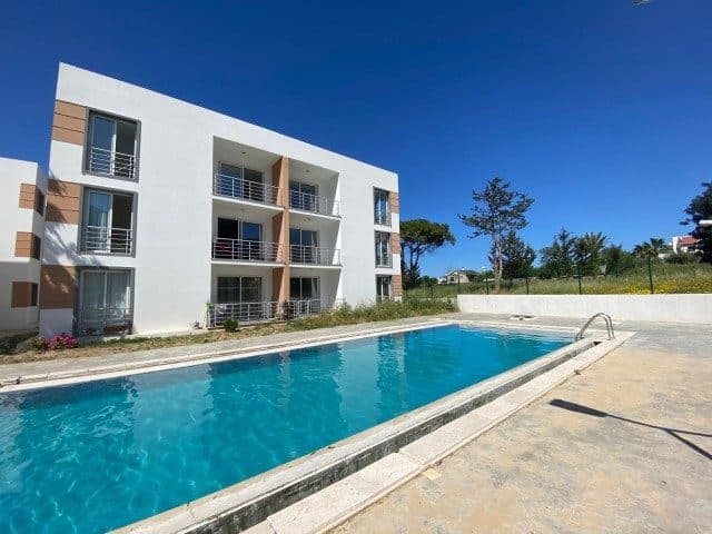 Rectangular pool and balconies in front of the apartment building