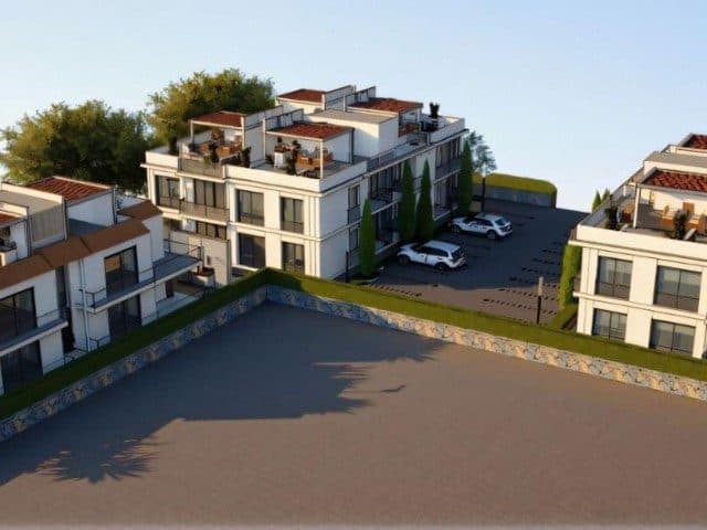 Teraslı apartman blokları ve açık otopark üstten görünüyor.