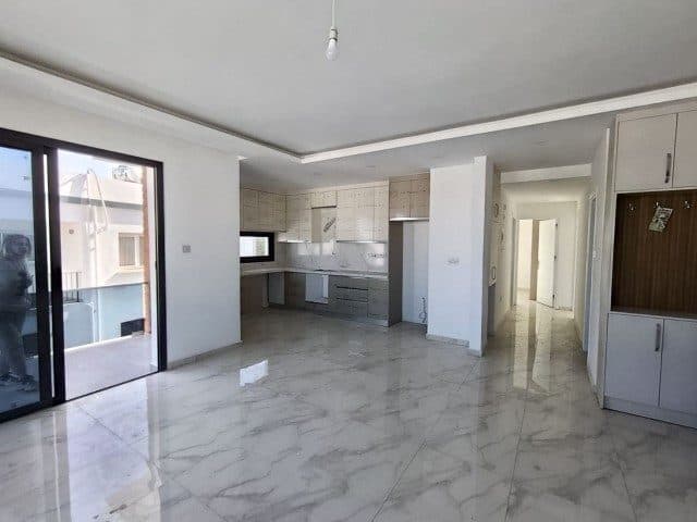 Mermer desenli zemin, açık mutfak ve sürgülü balkon kapısı