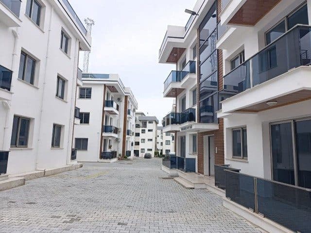 Açık renkli apartmanlar ve taş döşeli ortak avlu