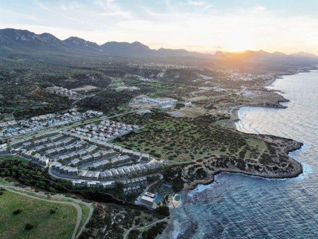 Kıyıdaki yerleşim, deniz ve dağlarla birlikte havadan görünüyor