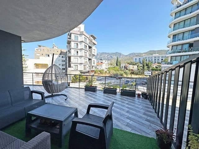 Oturma grubu, saksılar ve dağlara bakan geniş balkon