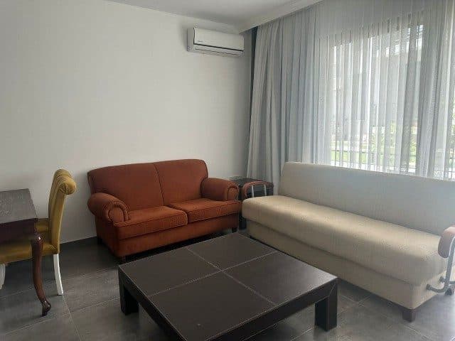 Turuncu ve açık renkli koltuklar, geniş perdeli pencere önünde