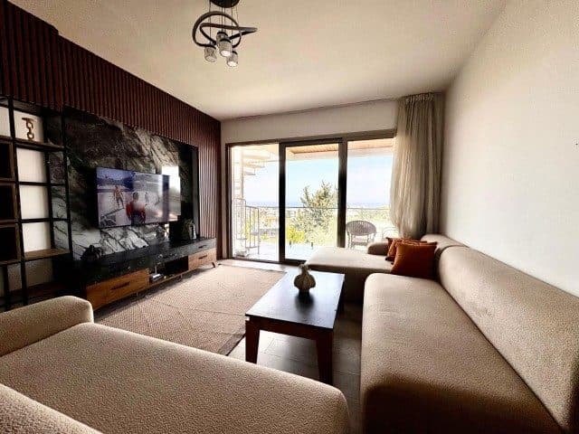 Köşe koltuk ve TV ünitesi, balkon kapısına bakıyor