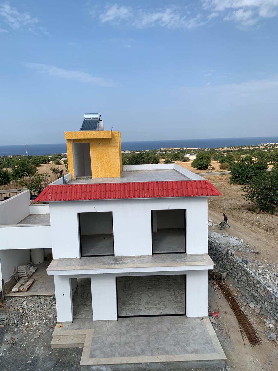 Deniz manzaralı, kırmızı çatılı, yapım aşamasında villa dış cephesi