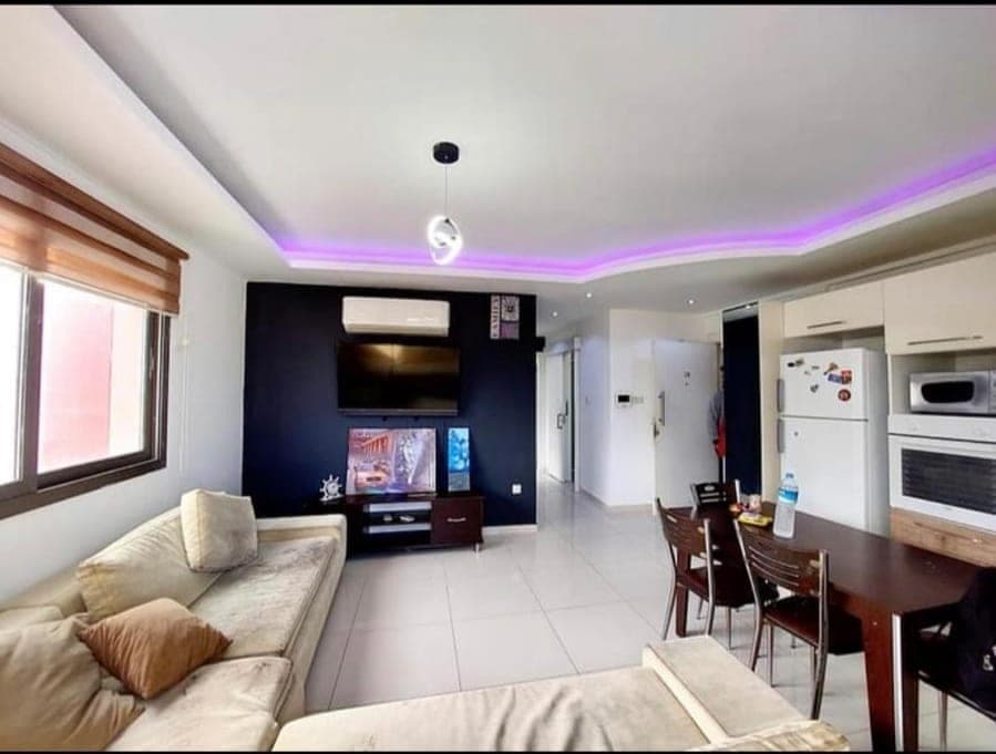 Spacious living room with seating area, dining table, and open-plan kitchen.