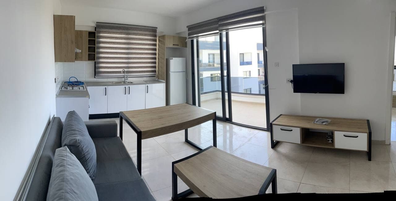Open-plan living room, kitchen, and sliding door to balcony
