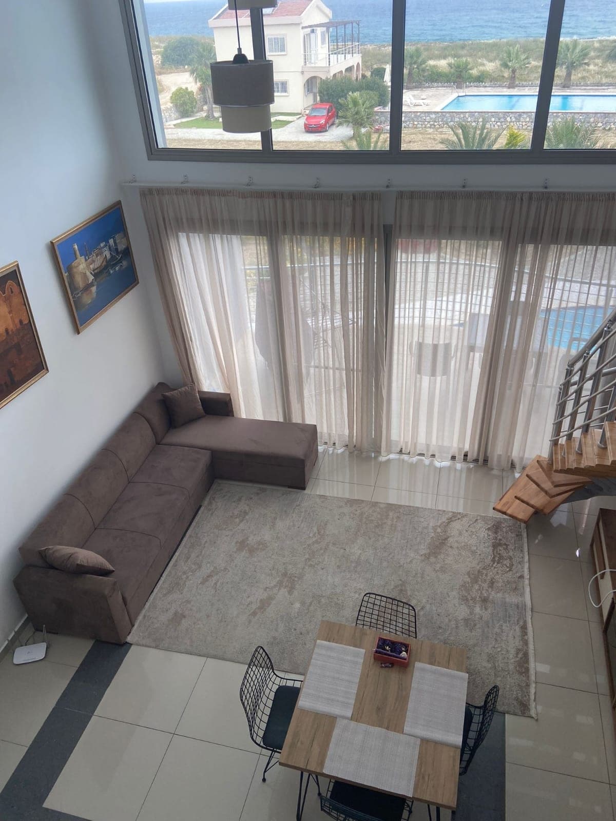 Deniz ve havuz manzaralı, yüksek tavanlı geniş salon ve yemek alanı.