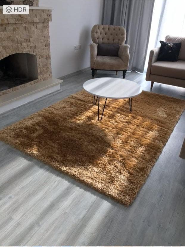 Şömineli, tekli koltuklu ve orta sehpası olan salon