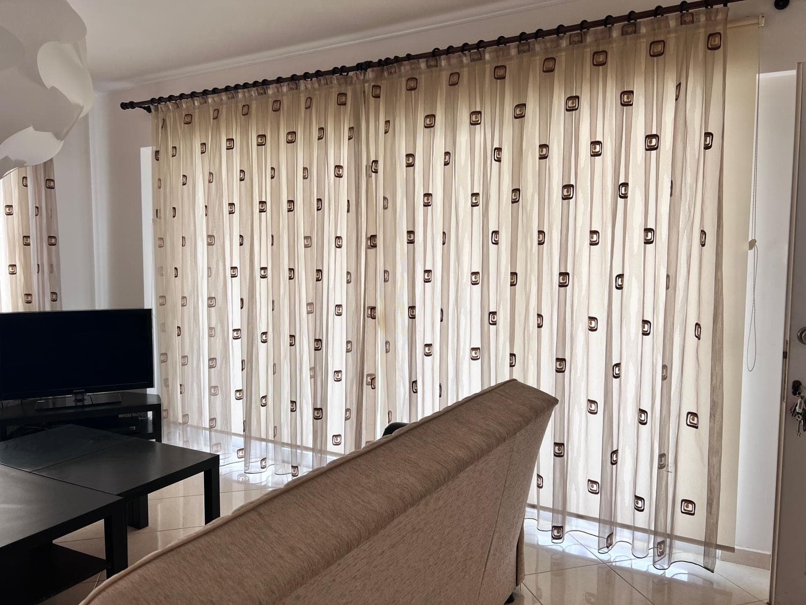 Close-up of a bright living room with television and sofa set.