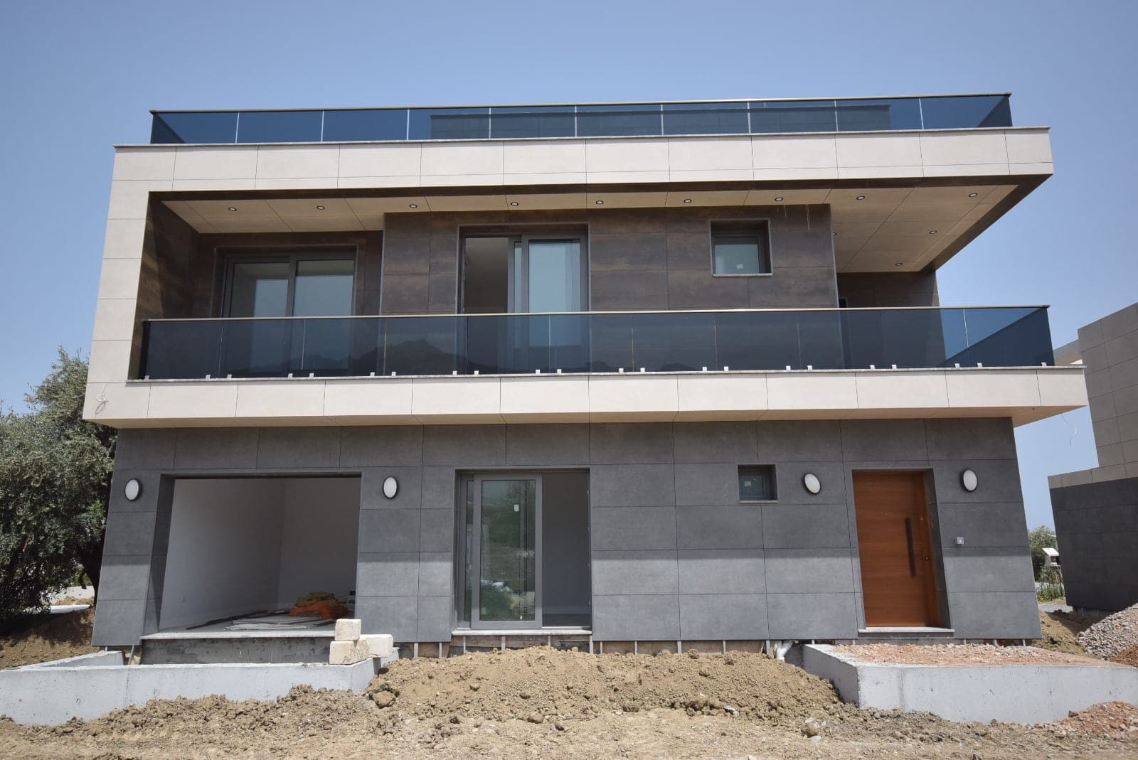 Exterior of a modern villa under construction with garden area.