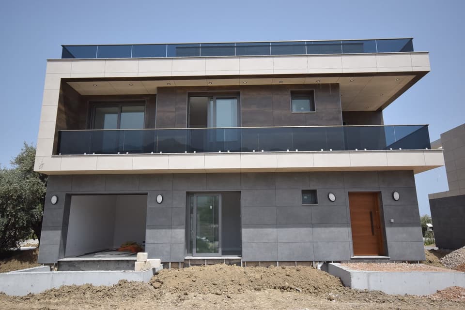 Exterior of a modern villa under construction with garden area.