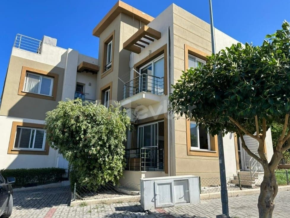 Modern designed apartment exterior in beige and brown tones, with balcony.