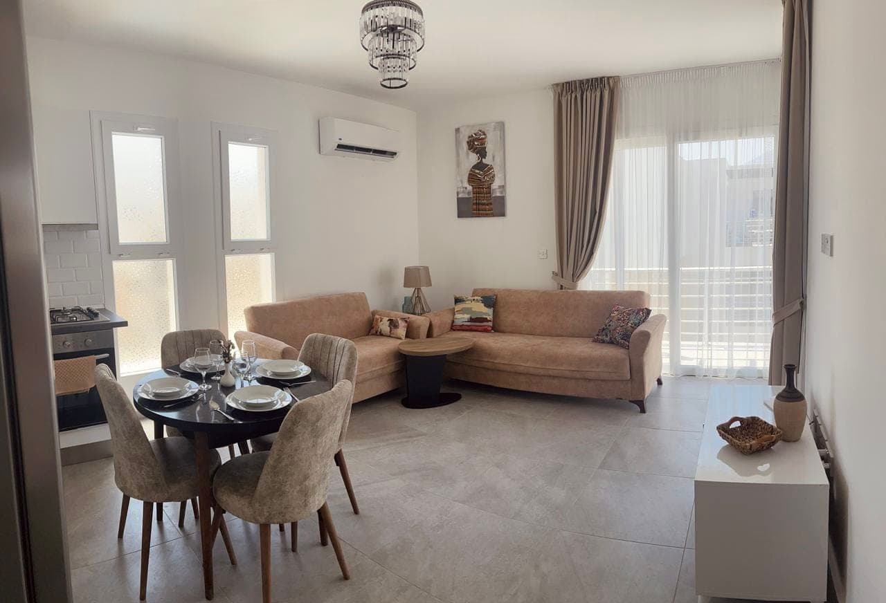Spacious living room with seating area, dining table, and open-plan kitchen.