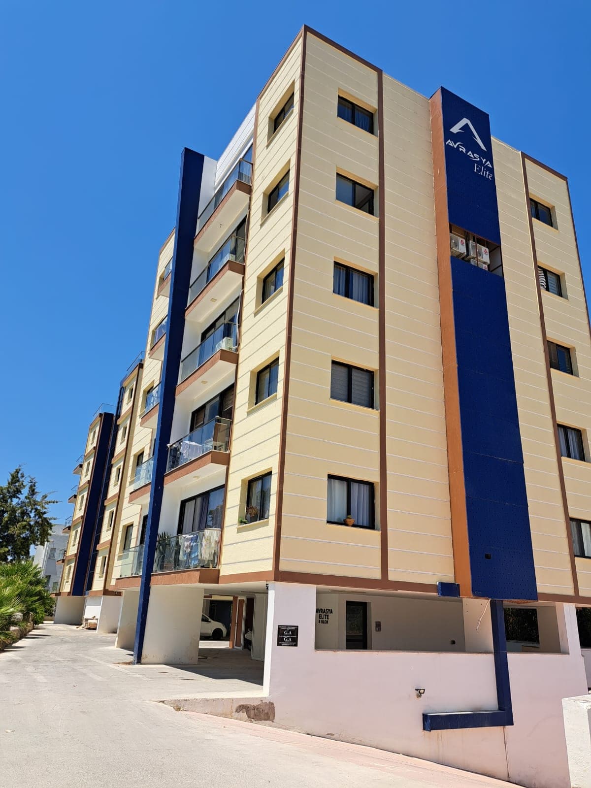 Exterior of a modern multi-story apartment building with balconies.