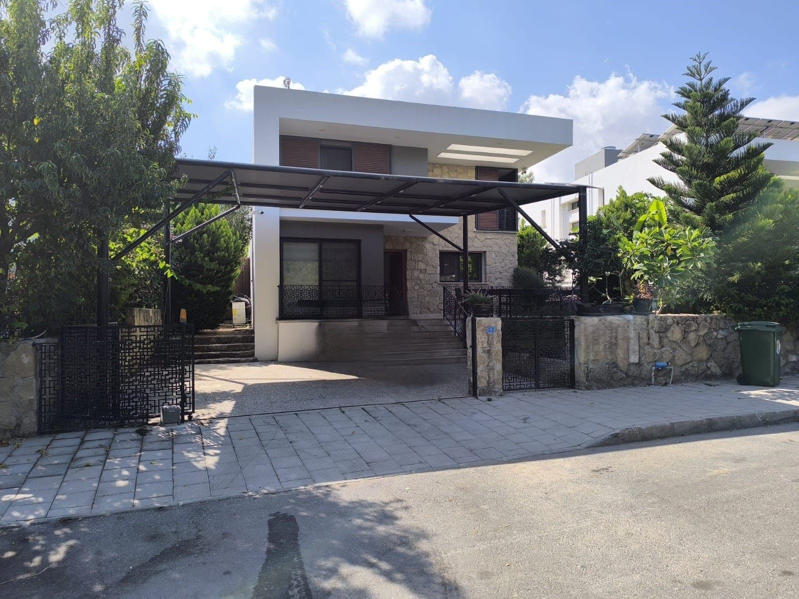 Modern villa exterior with spacious parking and green garden
