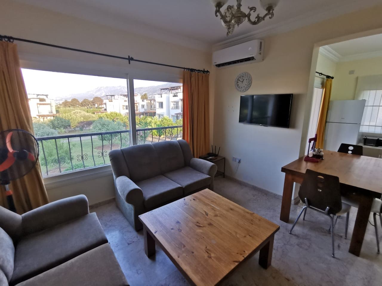 Living area, dining table, and large window with mountain view.