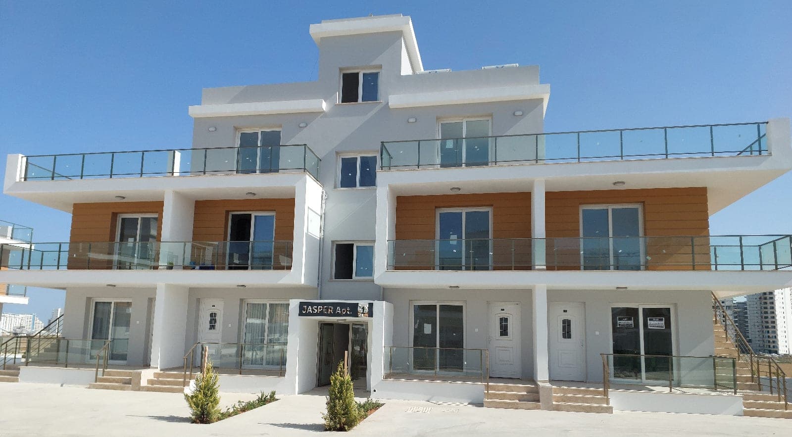 Modern tasarımlı, çok katlı apartman binasının dış cephesi ve balkonları.