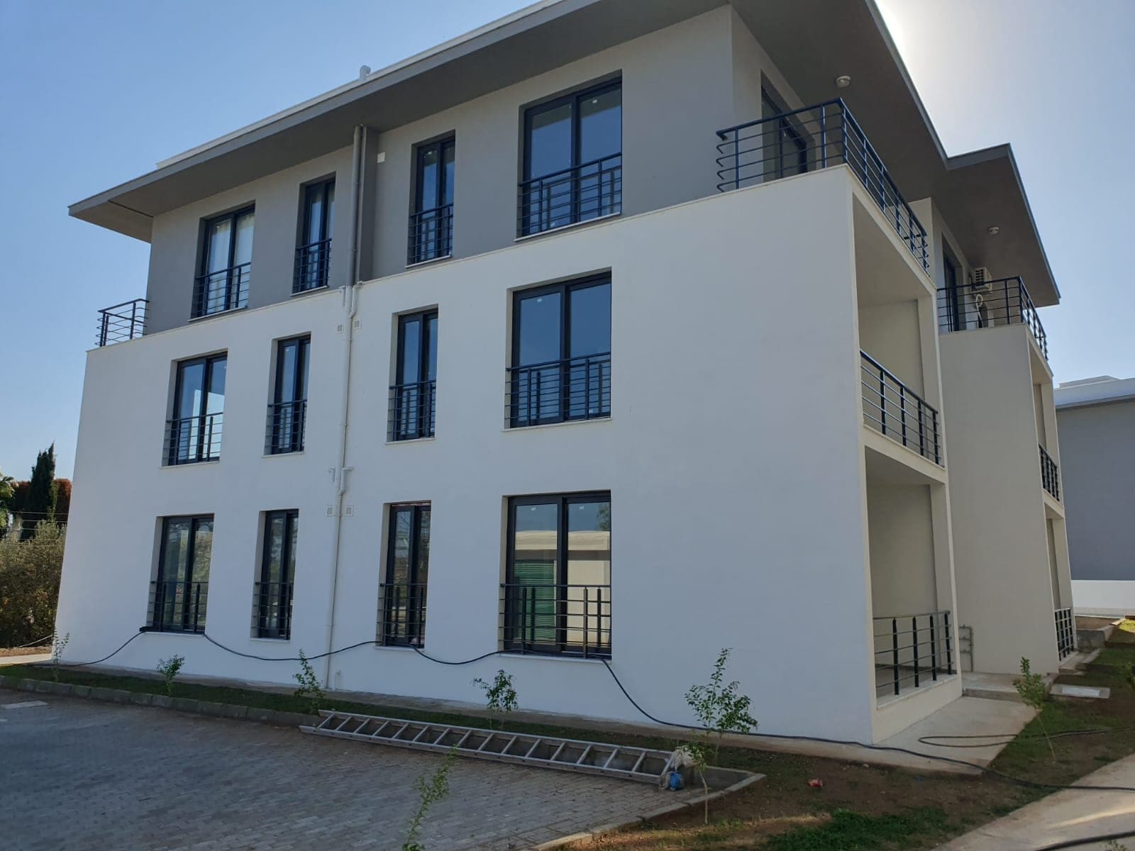 Exterior of a newly built apartment building with modern design and parking area.