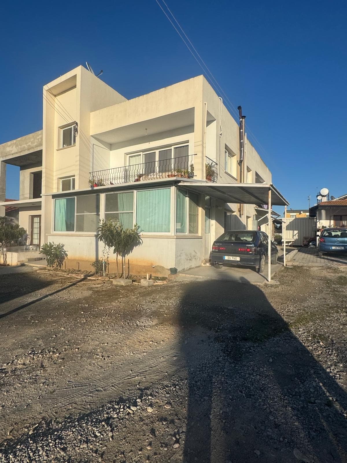 Apartment exterior with a large parking area and balcony.