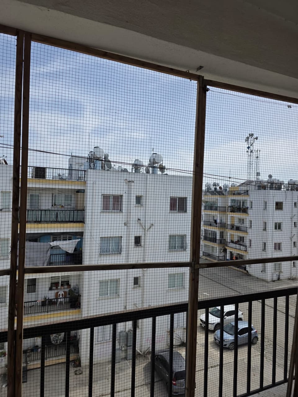 Balkondan karşı apartmanların ve otoparkın kuşbakışı görünümü
