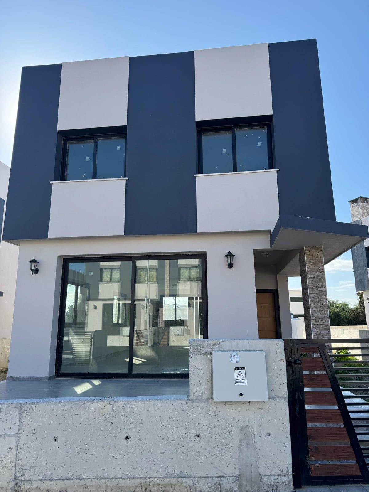 Front facade and garden entrance of a two-story villa with modern architecture.