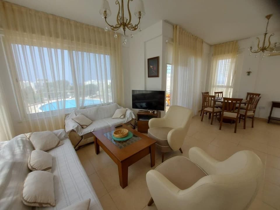 Geniş salon ve yemek alanı, havuz manzaralı pencere.
