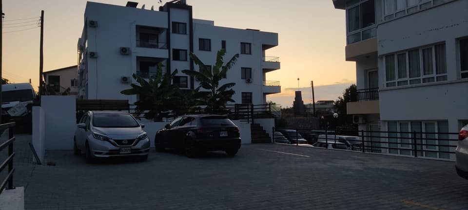 Akşamüstü ışığında apartman binası ve açık otopark alanı