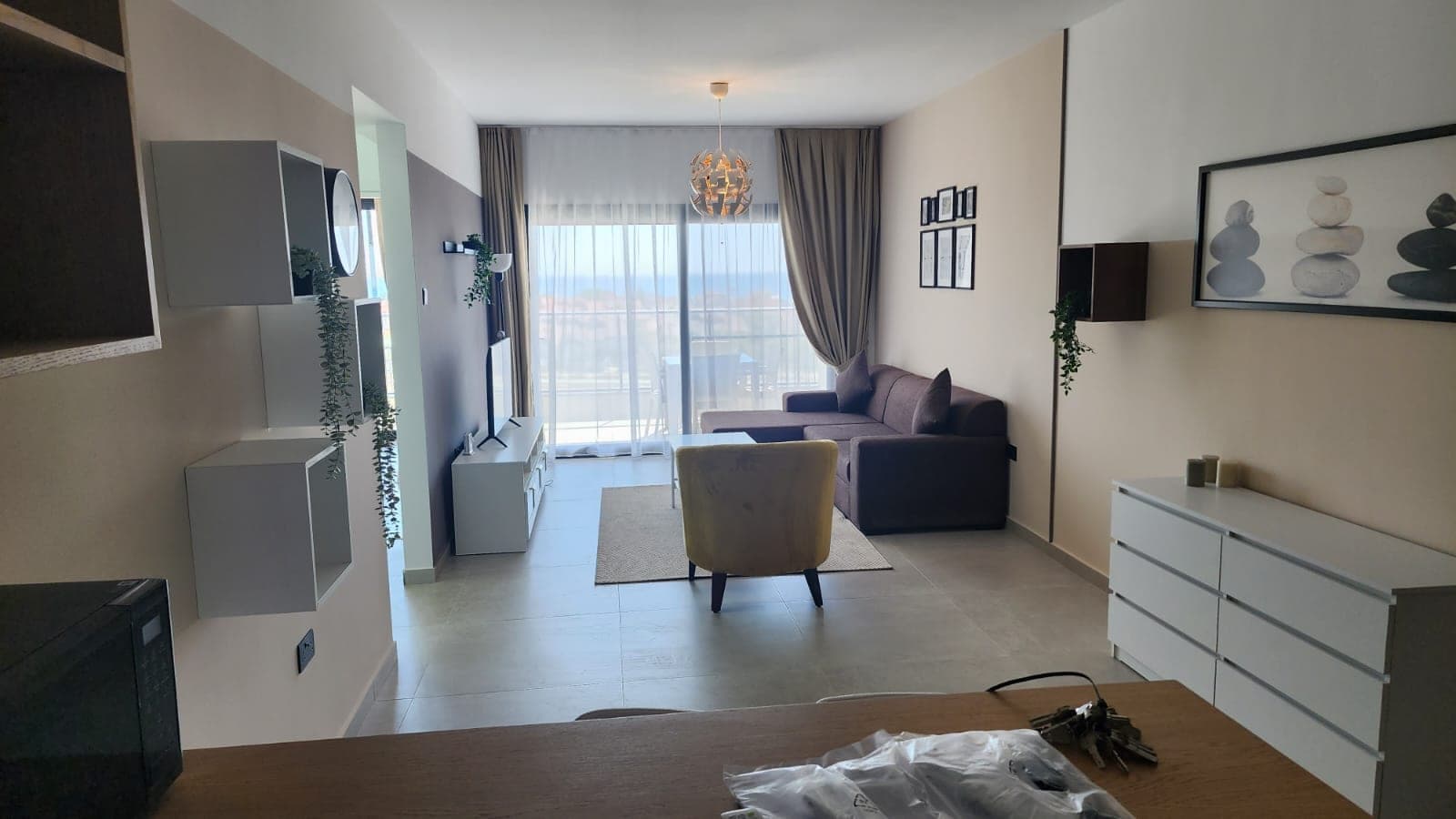 Living area with balcony door and outdoor view.