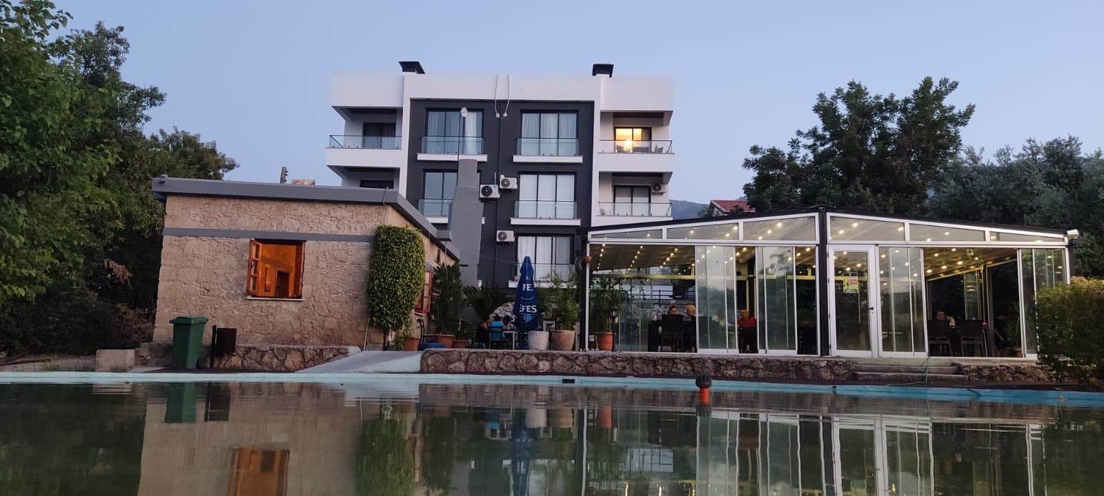 Apartment building, pool, and surrounding green areas.