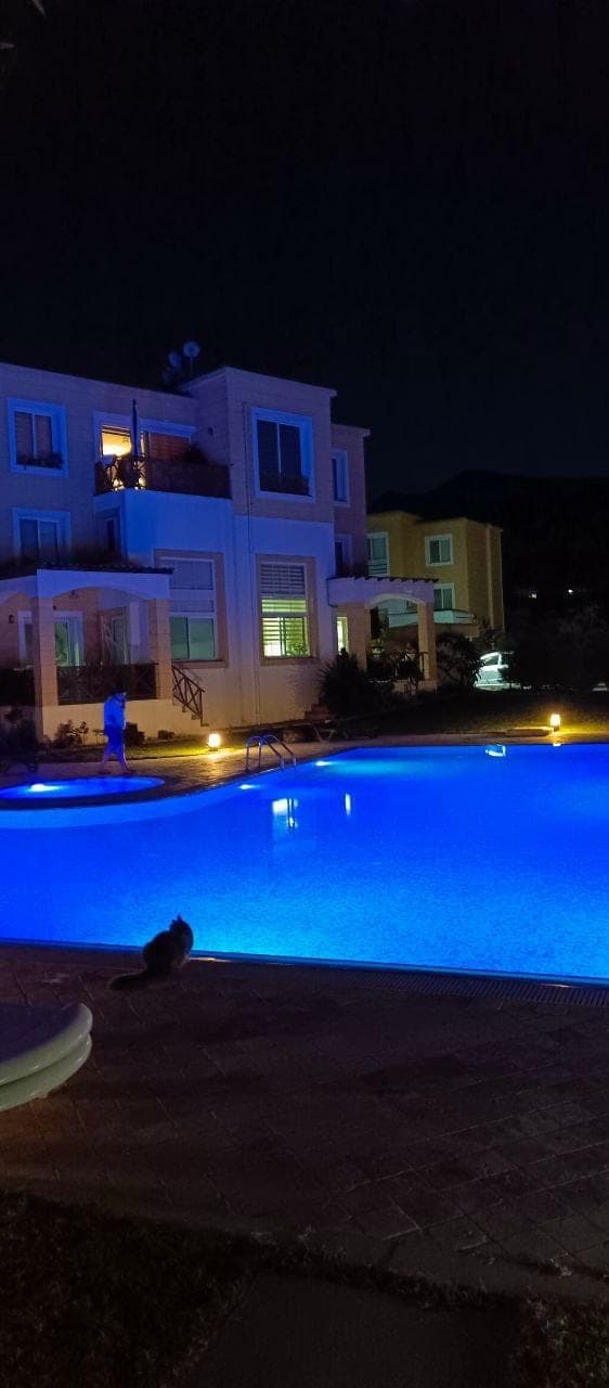 Evening illuminated pool and exterior of residential buildings